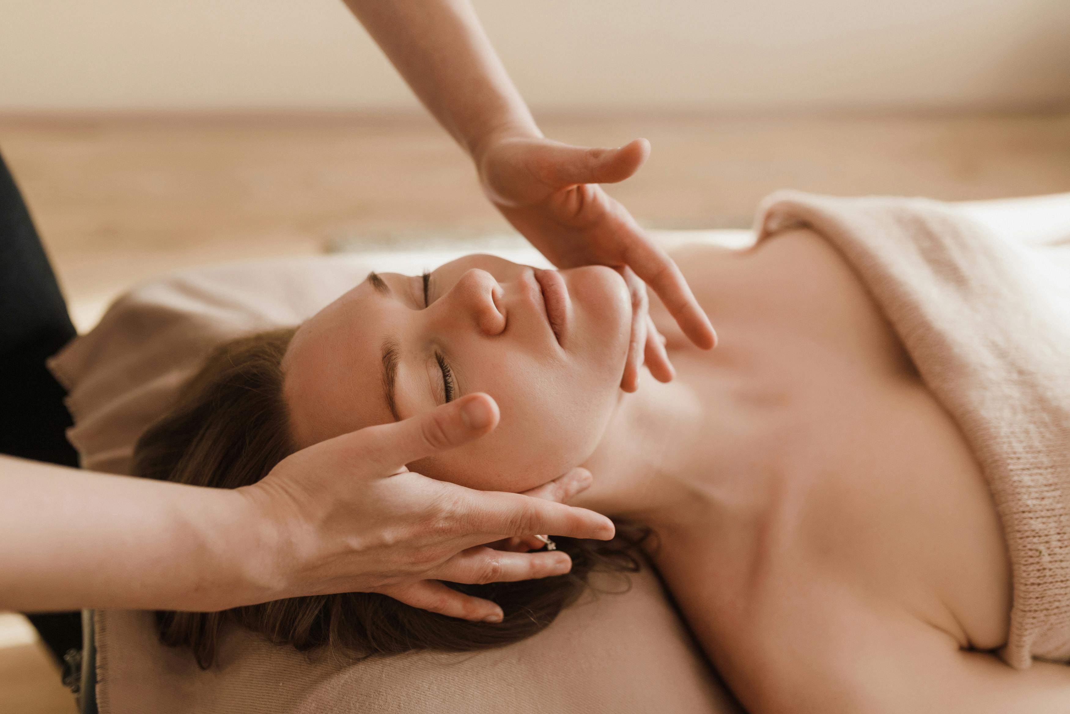 Woman receiving a relaxing face massage at a spa